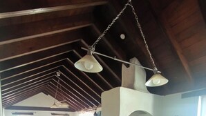 Una cuina àmplia amb un sostre alt, bigues de fusta i zona de menjador amb taula i cadires.