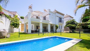 A residential property with a swimming pool, a covered patio, and a well-maintained lawn. - Luxury villa in the center of Marbella (Marbella)