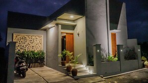 Una casa moderna con un ingresso luminoso, una parete decorativa e piante in vaso.