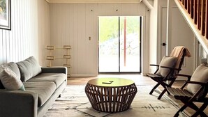 Una sala de estar moderna con un sofá, una mesa de centro de madera y una silla.