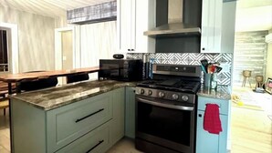 Una cocina con una isla central, estufa y microondas.