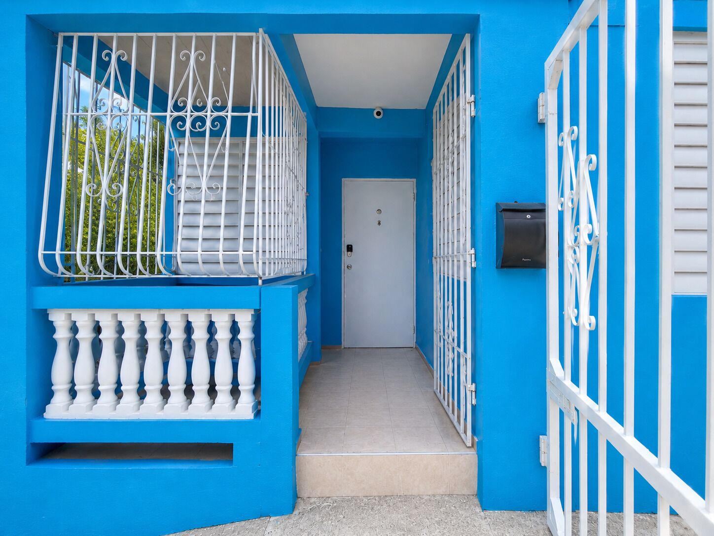 Un edificio azul con barandillas blancas y una puerta.