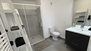 A modern bathroom with a shower, toilet, and sink. - Apartment in quiet residence (Cherbourg-en-Cotentin)