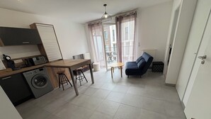 A compact living space with a kitchenette, a dining area, and a seating area. - Apartment in quiet residence (Cherbourg-en-Cotentin)