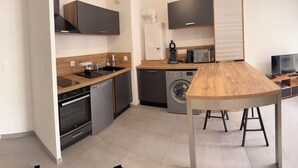A modern kitchen with a built-in oven, a dishwasher, and a sink. - Apartment in quiet residence (Cherbourg-en-Cotentin)
