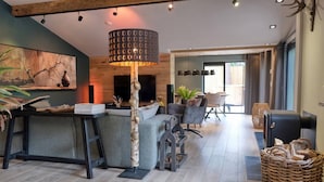 A modern living room with a sofa, a coffee table, a lamp, and a fireplace.
