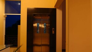 Un ascensor con detalles metálicos, un panel de control y un panel de vidrio con diseño decorativo.