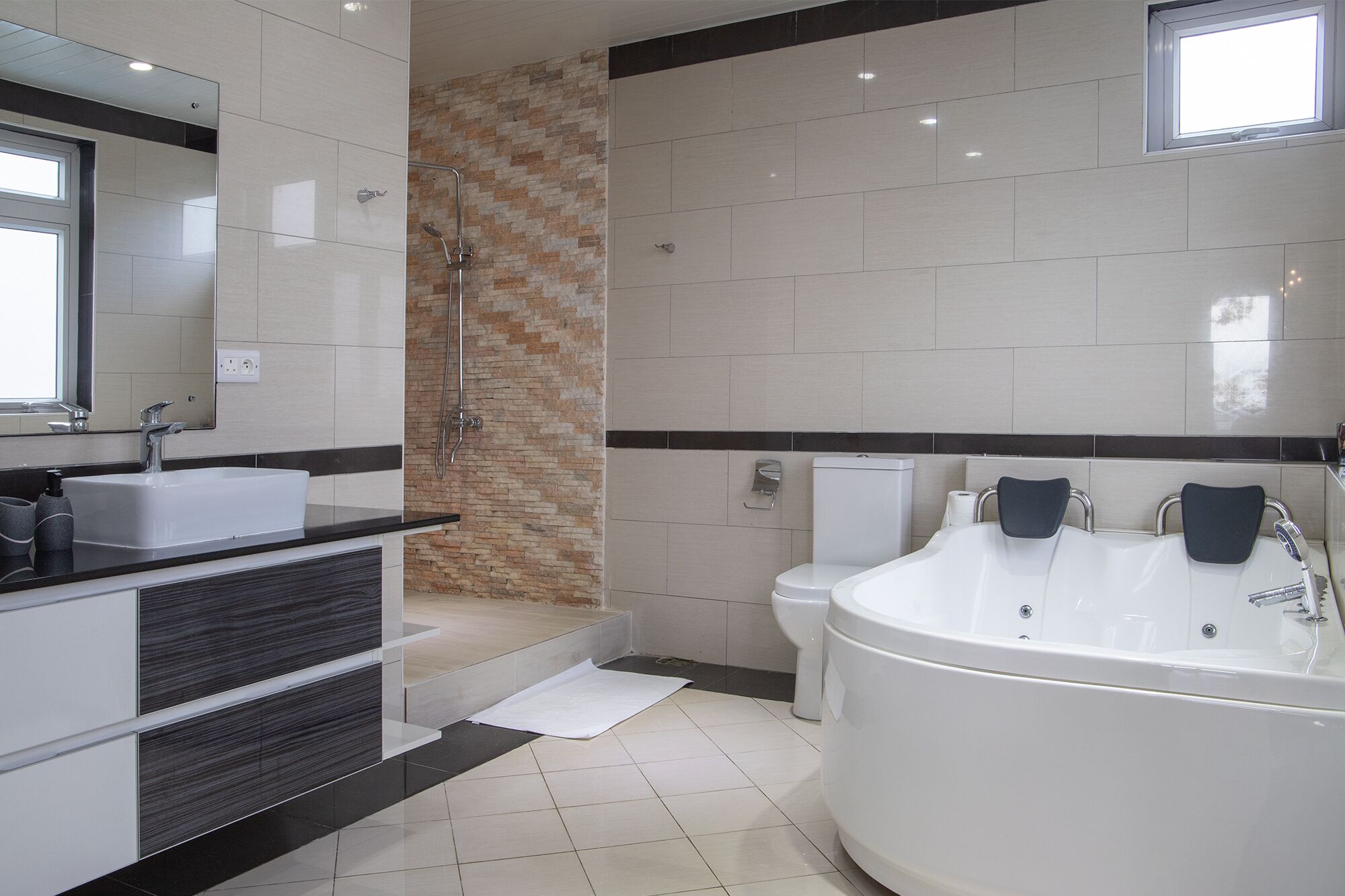 Ein modernes Badezimmer mit einer großen Badewanne, einer separaten Duschkabine und einem WC.