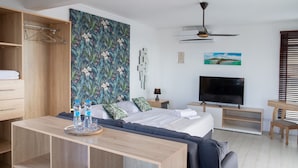 Een moderne hotelkamer met een bed, televisie, bureau en kledingkast.