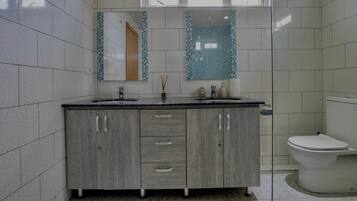 A bathroom with a wooden vanity, a sink, and a toilet.