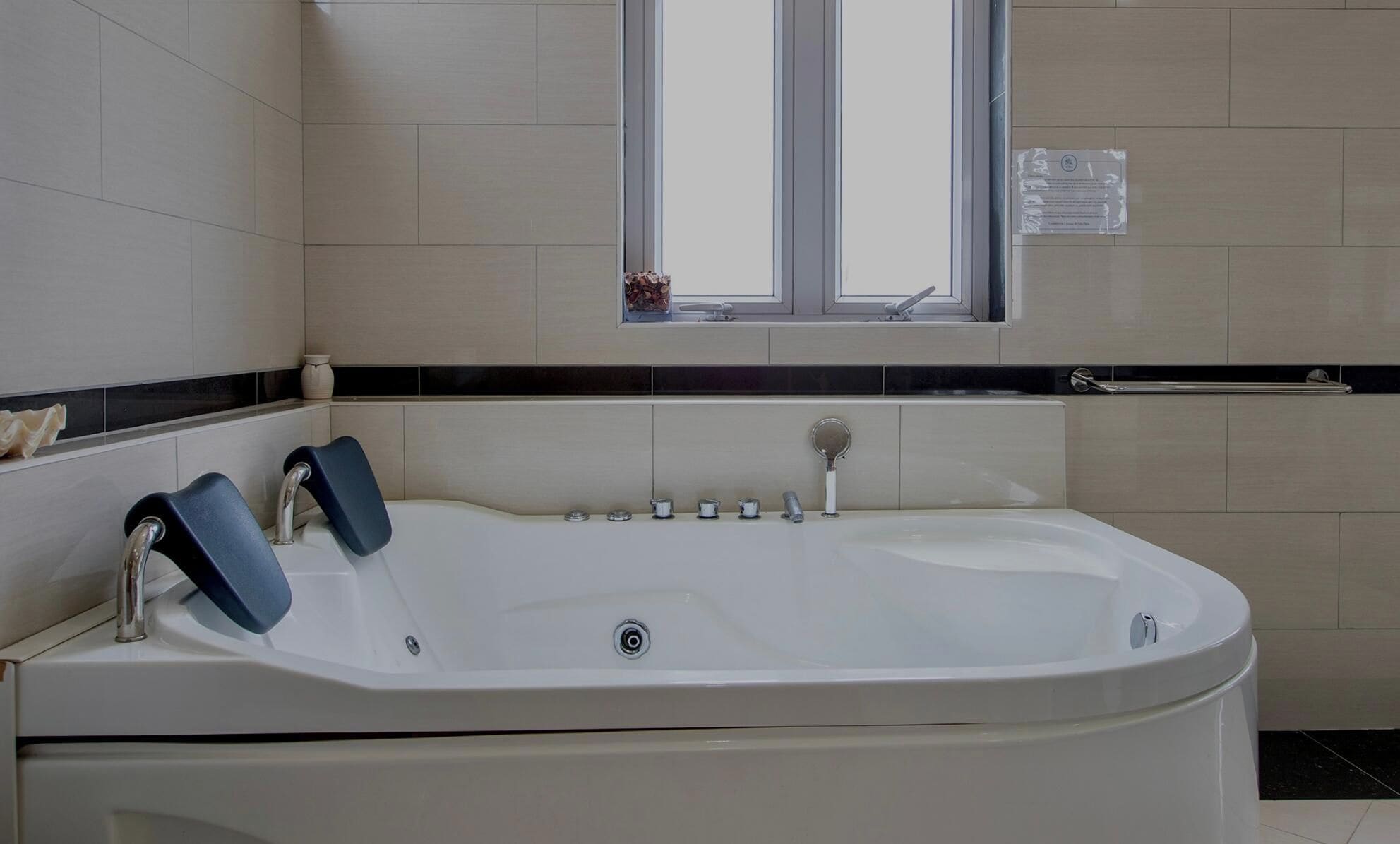 Un baño moderno con una bañera independiente, una ventana y un perchero para toallas.