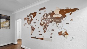Un mural con un mapa del mundo sobre una pared blanca y un suelo de madera.