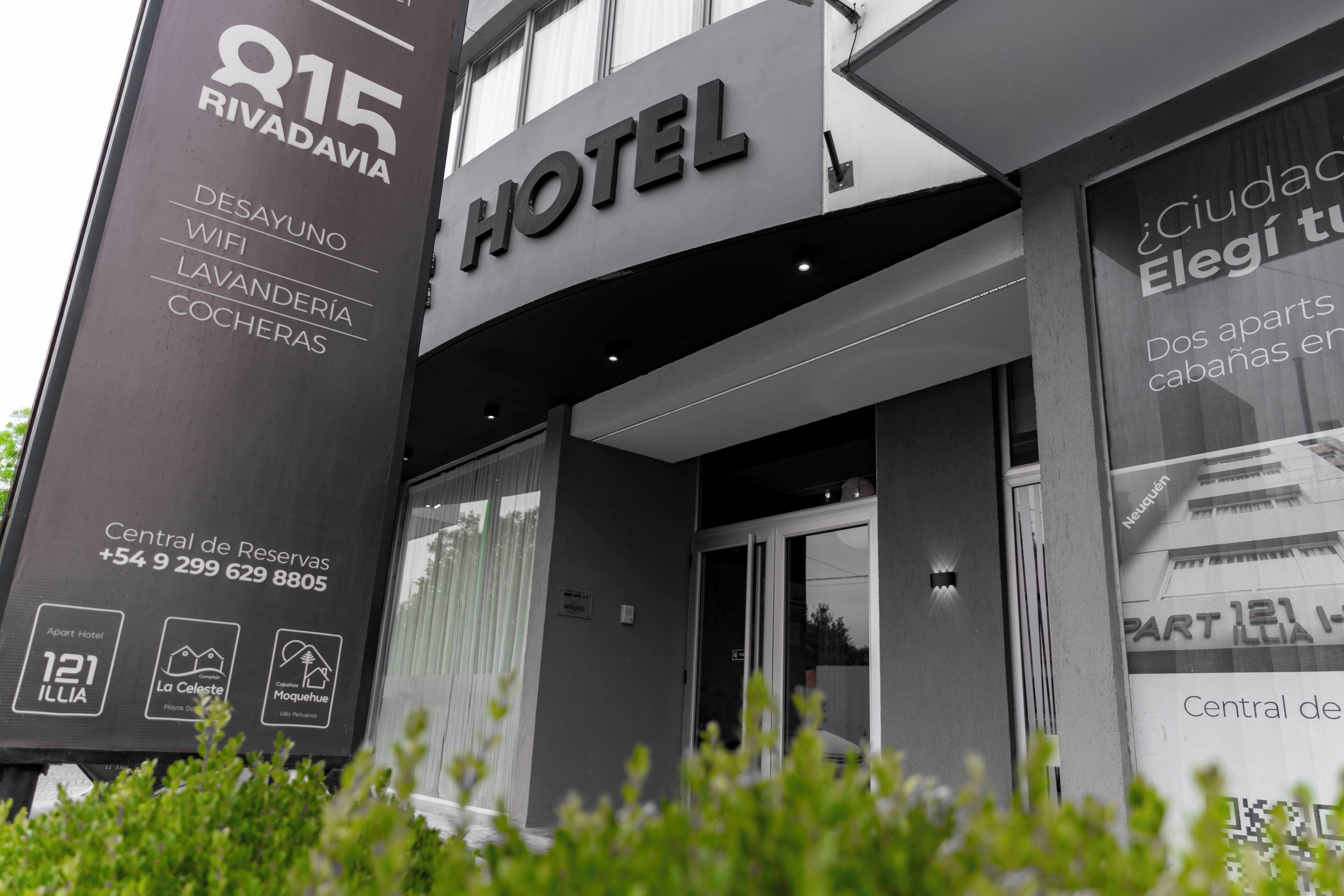 Ein Hotel Eingang mit Schild, das Annehmlichkeiten wie WLAN, Wäscheservice und Dusche anzeigt.