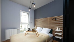 Un dormitorio moderno con cama, mesitas de noche, una ventana y un radiador.