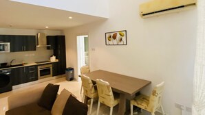 A modern apartment with a dining area, kitchen, and a living room with a sofa and chairs. - premier luxury apartment (Accra)