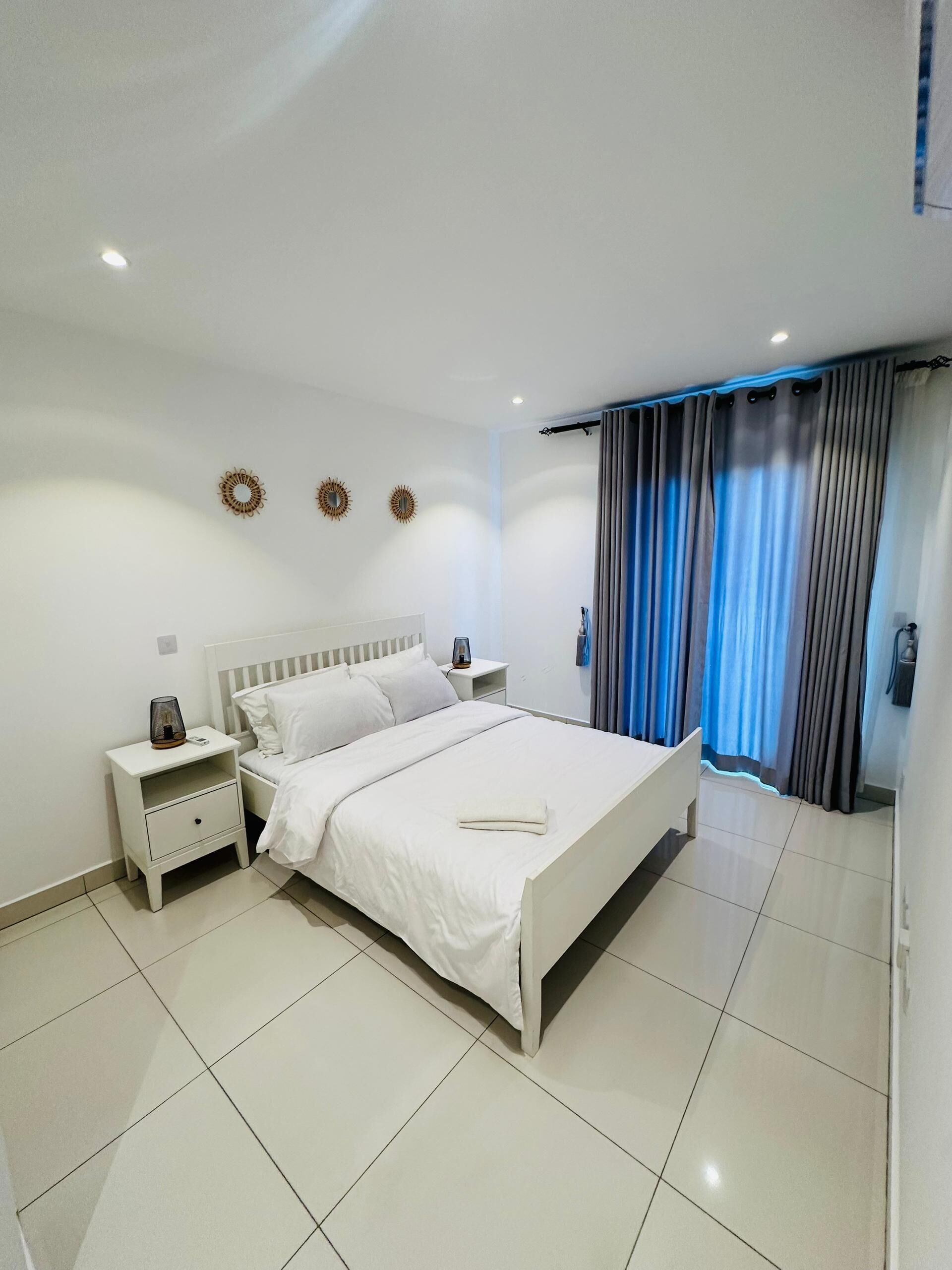 Un dormitorio moderno con una cama grande, dos mesitas de noche y una mesilla.