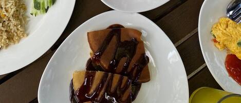 Diversos pratos, incluindo arroz, frituras e fatias de melancia, sobre uma mesa.