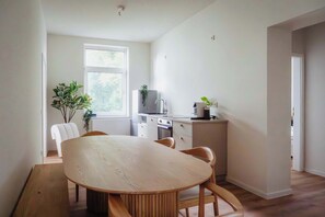 Una cocina moderna con armarios blancos, horno empotrado y una ventana.