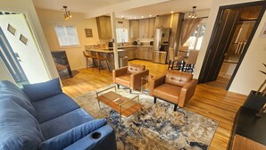 A modern living room with a blue sofa, a coffee table, and a patterned rug.