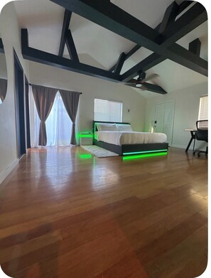 Ein Schlafzimmer mit Bett, Schreibtisch und Deckenventilator.