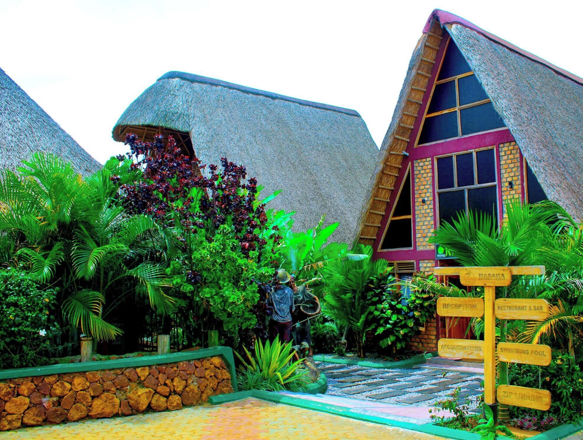 A resort with thatched-roof buildings, a swimming pool, and a signpost indicating amenities like a restaurant and bar.