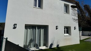 A two-story building with a white exterior, a tiled roof, and a large sliding glass door. - House with swimming pool in Provence near la sainte victoire (Fuveau)