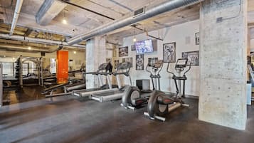 A gym with treadmills, elliptical machines, and weightlifting equipment.