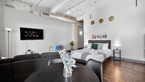 Une chambre d’hôtel moderne équipée d’un lit, d’une télévision, d’une table à manger et d’un canapé.