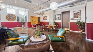 A spacious lounge area with leather chairs, a dartboard, and a table with decorative items. - Modern Downtown 2BR | Pool, Laundry, Valet Parking (Dallas)