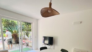 A modern living room with a round table, four chairs, a flat-screen TV, and a ceiling fan. - Bay of Saracens, renovated apartment 6 people with garden parking space (Varigotti)