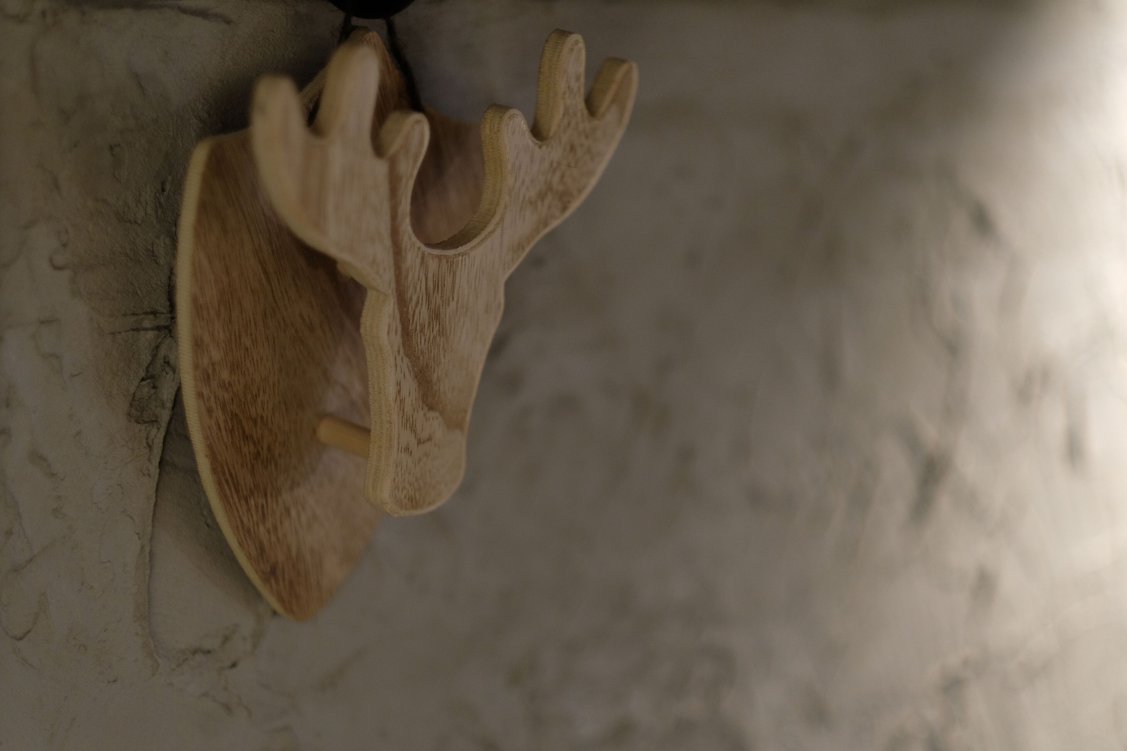 A wooden headboard with a carved antler design.