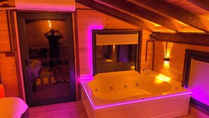 A room with a large bathtub, wooden walls, and a ceiling fan. - Of Kartepe Bungalov & İkiz Villalar (Of)