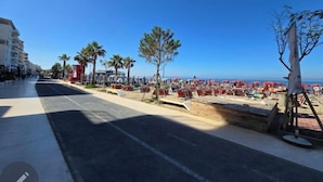 A beachside promenade with palm trees, beach umbrellas, and a clear view of the sea. - Prestige Beach Apartament Durres (Durres)