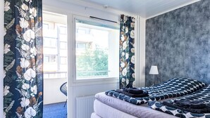 A bedroom with a bed, a window, and a view of the outside.
