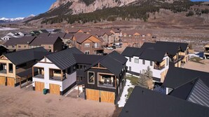 Un quartier résidentiel avec des maisons modernes, dont certaines sont dotées de balcons, et un paysage montagneux en arrière-plan.