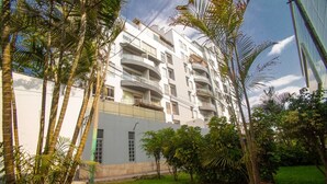 A multi-story residential building with balconies, surrounded by lush greenery and a well-maintained lawn. - NICE DUPLEX APARTMENT CHACARILLA DEL ESTANQUE SAN BORJA NEAR PENTAGONIT (San Borja)