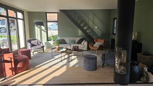 A modern living room with a sofa, armchairs, a coffee table, and a fireplace. - 10 mn from Wimereux beach, charming renovated farmhouse in a green setting (Wierre-Effroy)