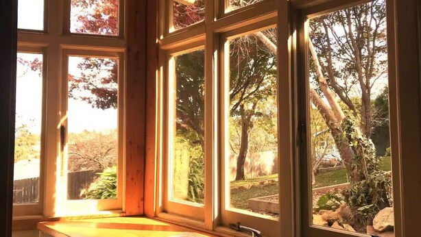 A kitchen with a large window overlooking a garden. - Idlehour - central, cosy classic mountain cottage (Katoomba)