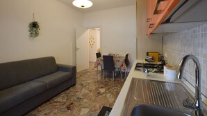A compact kitchen with a sink, a dining table, and a sofa. - B&b on the course, Reggio Calabria (Reggio Calabria)