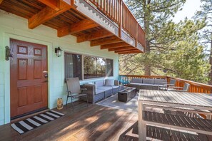 A wooden deck with a built-in seating area, a door, and a window.