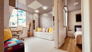 Ein modernes Schlafzimmer mit Bett, Schreibtisch und Sofa.