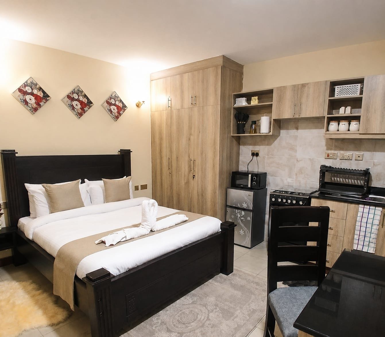 Una habitación de hotel con cama, kitchenette y zona de comedor.