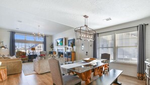 A spacious living area with a large dining table, comfortable seating, and a fireplace. - Upscale Waterfront Boat Lift~Kayaks~Pets~Sleeps12 (Galveston)