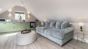 Moderni loft-tyylinen asunto, jossa on keittiö, sohva ja lamppu.