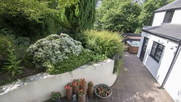 Ein Gartenbereich mit verschiedenen Kübelpflanzen und einem Whirlpool.
