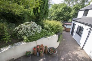 Un espace jardin agrémenté de diverses plantes en pot et d’un jacuzzi.
