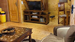Ein Holzinnenraum mit einer Treppe, einem Fernseher und einem Sofa.