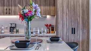 Una cocina moderna con una isla central, armarios de madera y un jarrón con flores.