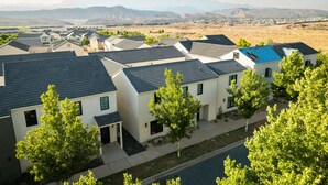 Una zona residencial con casas modernas, cielo despejado y montañas a lo lejos.