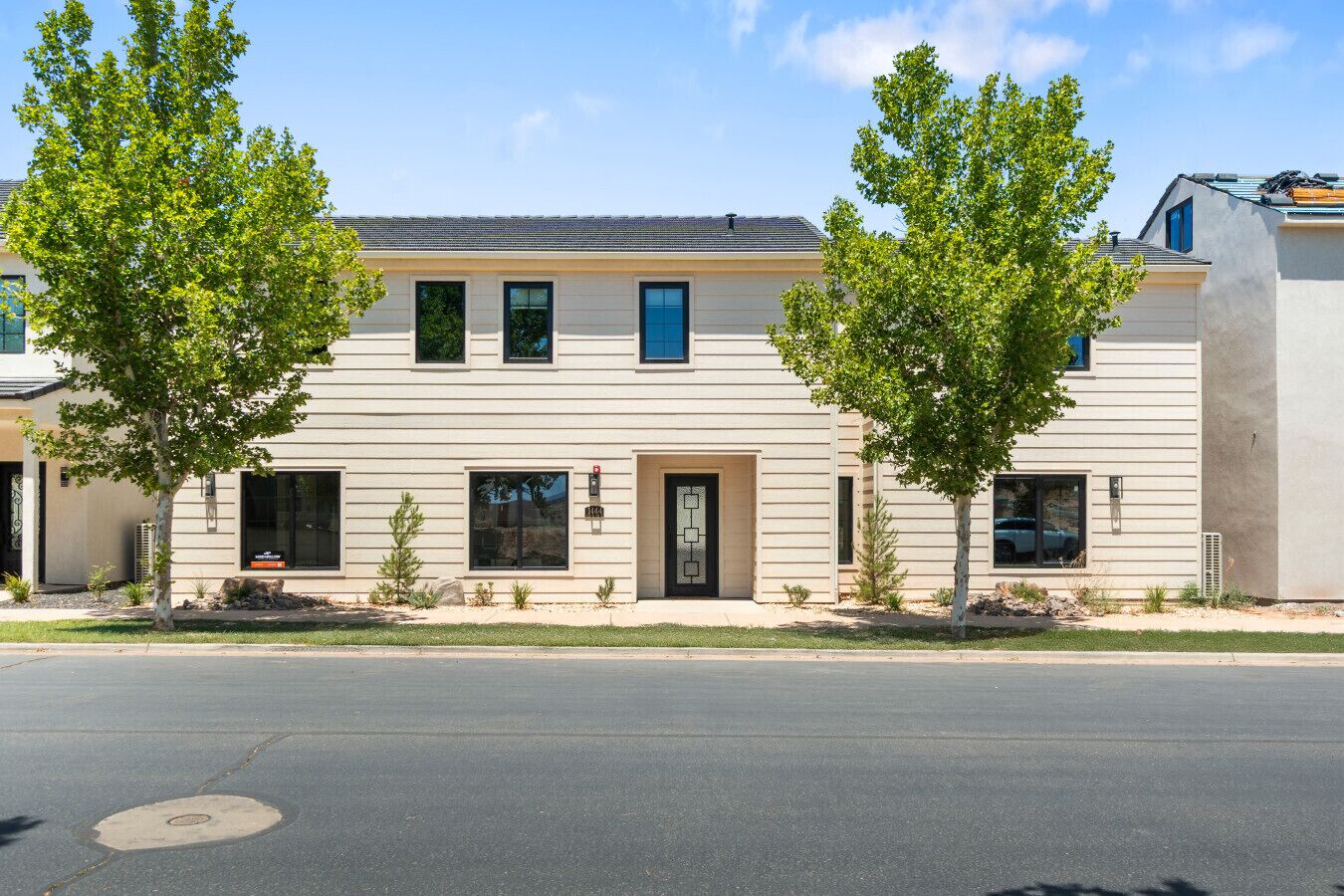 A two-story building with a flat roof, large windows, and a door with a glass panel.